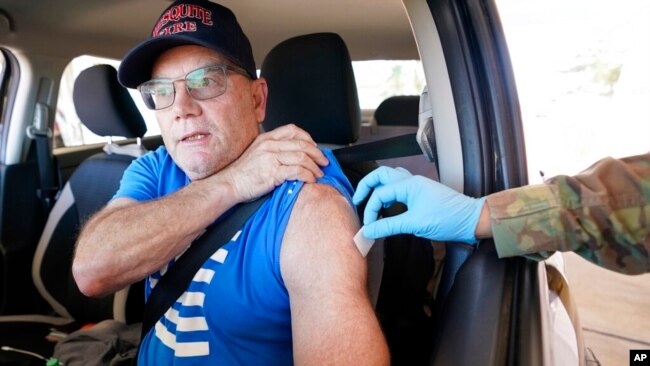 Jeffrey Dillon receives a Pfizer COVID-19 vaccine booster shot at the Dallas County Health and Human Services drive-up vaccine site in Mesquite, Texas, Nov. 30, 2021. (AP Photo/LM Otero)