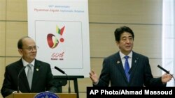 Myanmar's President Thein Sein, left, listens as Japanese Prime Minister Shinzo Abe speaks during a joint press conference after their talks at Abe's official residence in Tokyo, Sunday, Dec. 15, 2013. Japan and Myanmar are commemorating the 60th annivers