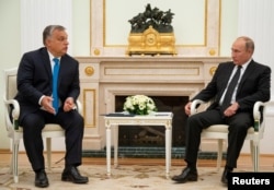 Hungarian Prime Minister Viktor Orban speaks with Russian President Vladimir Putin during their meeting at the Kremlin in Moscow, Sept. 18, 2018.