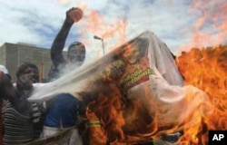 Supporters of the fledgling National Freedom Party, the NFP, burn T-shirts bearing the image of Inkatha Freedom Party, IFP, leader Mangosuthu Buthelezi in Durban, South Africa, recently