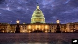 Lights shine inside the U.S. Capitol Building as night falls in Washington, Jan. 21, 2018. 