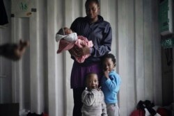 In this Sept. 23, 2019 photo, Prudence Aimee, 30, from Cameroon poses for a photo with her children, from left Ange, Wifrid, 1, and William, 3, aboard the humanitarian rescue ship Ocean Viking in Italian waters off the Sicilian town of Messina, southern Italy, hours before disembarking. Aimee left Cameroon in 2015, and when her family heard nothing from her for two years, they thought she was dead. But she was in detention and incommunicado. In nine months at Libya's Abu Salim detention center, she saw “European Union milk” and diapers delivered by UN staff pilfered before they could reach migrant children, including her toddler son. Aimee herself would spend two days at a time without food or drink. (AP Photo/Renata Brito)