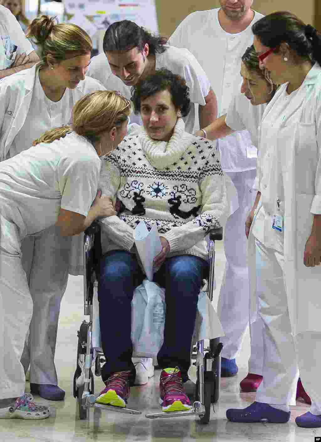 Assise sur un fauteuil roulant au milieu du personnel de santé, Teresa Romero, infirmière auxiliaire espagnole, guérie du virus Ebola, a été libéré d&#39;un hôpital de Madrid un mois après qu&rsquo;elle a été confirmée infectée par le virus. Elle est la première personne connue à avoir contracté la maladie en dehors de l&#39;Afrique de l&#39;Ouest dans la dernière flambée. (AP Photo / Andres Kudacki) 