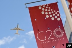 A jet liner flies over the G-20 summit venue at the Costa Salguero Center in Buenos Aires, Argentina, Nov. 28, 2018.