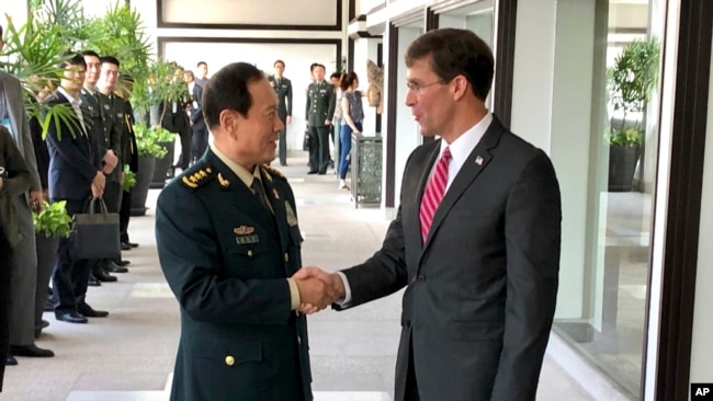 资料照片：中国国防部长魏凤和（左）和美国国防部长埃斯珀在泰国曼谷会见时握手。（2019年11月18日）
