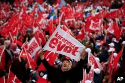 A supporter of Turkey's President Recep Tayyip Erdogan, waiting for his speech, waves a banner that reads in Turkish: 'Our decision is Yes', referring to the upcoming referendum, during a rally in the Black Sea city of Rize, Turkey, April 3, 2017.