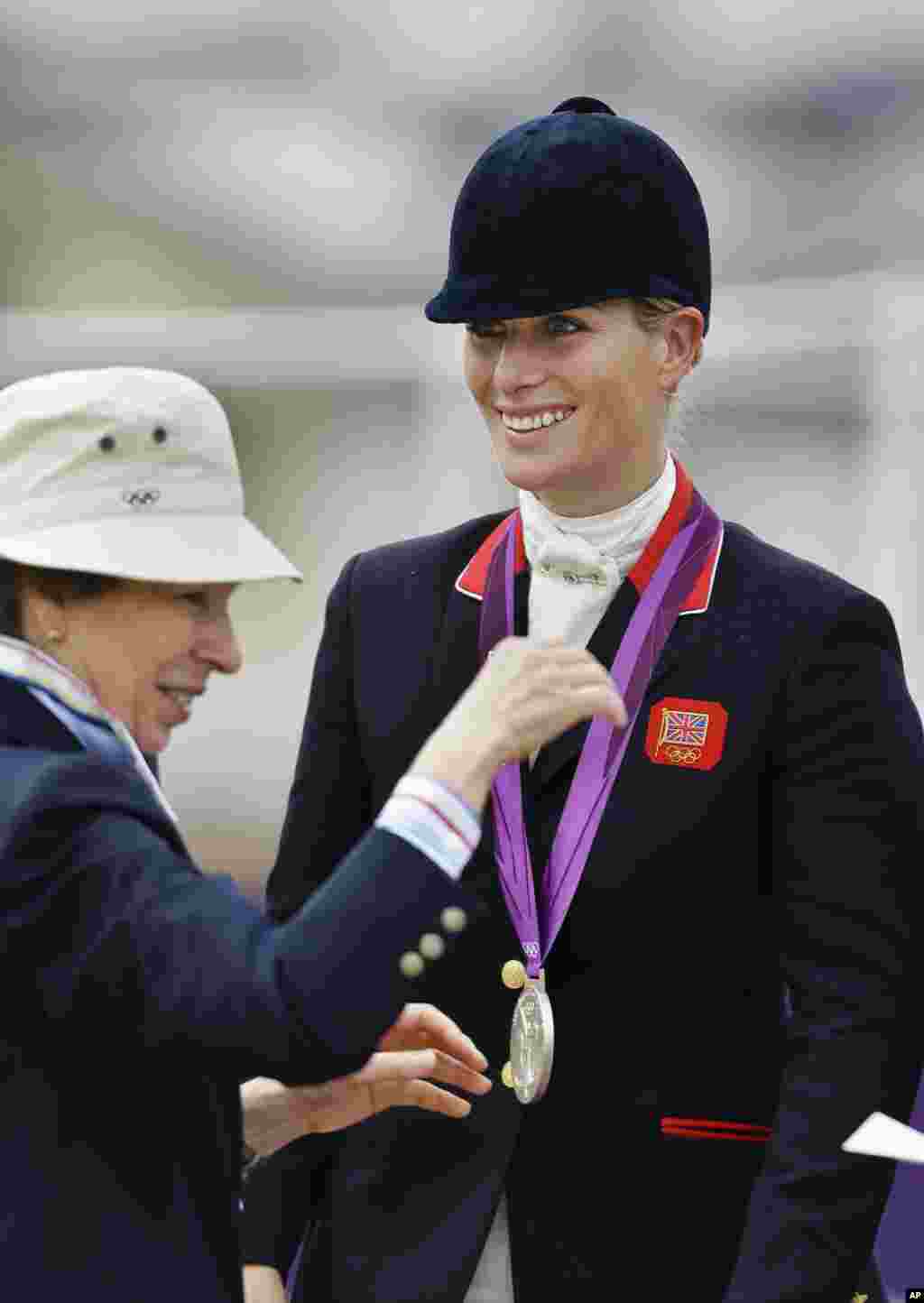 Britain's Zara Phillips, right, receives a silver medal from her mother Princess Anne, left, after Britain won silver in the team equestrian eventing competition at the 2012 Summer Olympics, July 31, 2012, at Greenwich Park in London.