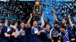 以79比62击败密西根大学队男蓝队、夺取NCAA冠军的维拉诺瓦大学队男篮队高举奖杯欢庆胜利。（2018年4月2日）