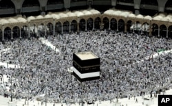 Muslim pilgrims prepare themselves for Friday prayers in front of the Kaaba, Islam's holiest shrine, at the Grand Mosque in the Muslim holy city of Mecca, Saudi Arabia, Sept. 9, 2016.