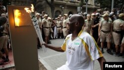 3일 올림픽 성화가 리우데자네이루에 도착한 직후 시민대표가 시내 5개 성화 보존지점 중 한 곳에 불을 옮겨 붙이고 있다.