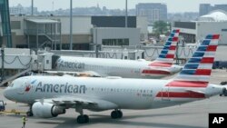Penumpang American Airlines bersiap untuk keberangkatan di dekat terminal di Bandara Internasional Boston Logan, di Boston. (Foto: AP)