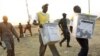 Election officials carry ballot boxes moments after polls closed in 2011 in Juba, in what was then southern Sudan.