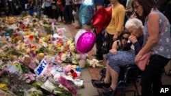 Women cry after placing flowers in a square in central Manchester, Britain, May 24, 2017, after the suicide attack at an Ariana Grande concert that left more than 20 people dead.