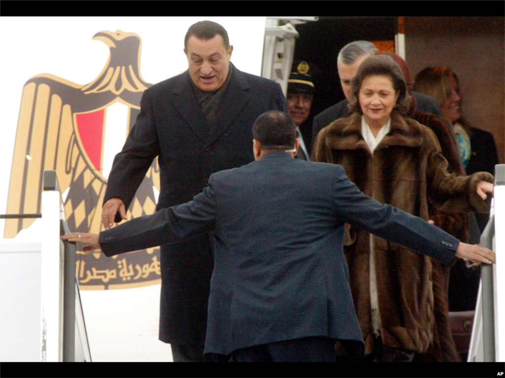 Seorang petugas keamanan membuka jalan bagi Presiden Mesir Hosni Mubarak, kiri, dan istrinya Suzanne, saat mereka tiba di bandara Tegel Berlin, 18 Februari 2003 dalam kunjungan dua harinya ke Jerman.