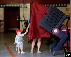 یک رای دهنده و فرزندش در نیوجرسی رای خود را روی ماشین رایگیری اعمال می کند.
