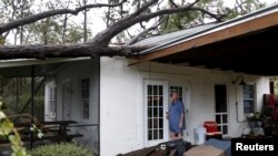 Andrew Lamonica inspecciona un árbol que cayó en su casa después del paso del Huracán Michael en Panama City Beach, Florida. Octubre 10, 2018