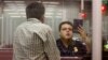 FILE - A Customs and Border Protection officer checks the passport of a non-resident visitor to the United States at McCarran International Airport, Dec. 13, 2011, in Las Vegas. 