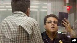 A Customs and Border Protection officer checks the passport of a non-resident visitor to the United States inside immigration control at McCarran International Airport, Tuesday, Dec. 13, 2011, in Las Vegas.