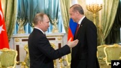 Russian President Vladimir Putin, left, speaks to Turkey's President Recep Tayyip Erdogan during their meeting in the Kremlin in Moscow, Russia, March 10, 2017. The talks focused on Syria, where Russia and Turkey have launched a joint mediation effort and coordinated their military action against the Islamic State group.