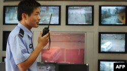 ایک چینی پولیس افسر کلوز سرکٹ کیمرون کی فیڈ چیک کرتے ہوئے،۔ فوٹو اے ایف پی 12 جولائی 2009