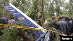 People gather at the scene where a police helicopter crashed at a forest in the Kibiko area of Ngong township, on the outskirts Nairobi, June 10, 2012. 