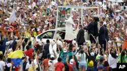 Warga menyambut kedatangan Paus Fransiskus yang kemudian memimpin Misa di kota Villavicencio, Kolombia, Jumat (8/9).