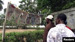 Des Togolais lisent les nouvelles du jour à Lomé, Togo, le 19 mai 2005.