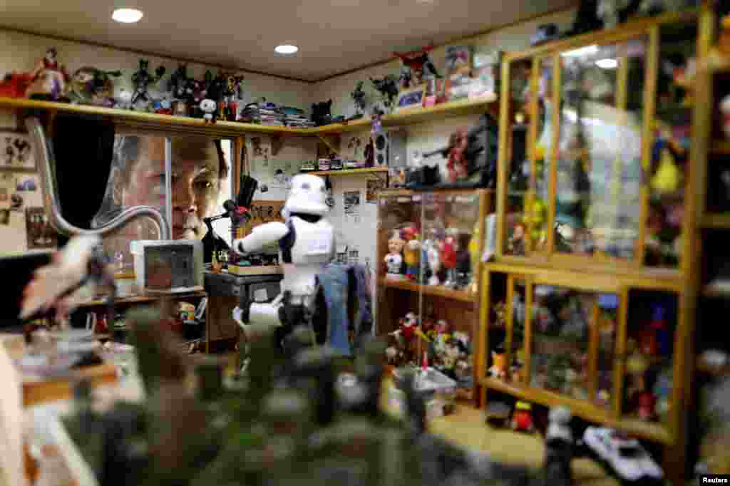 Taiwanese artist Hank Cheng stands with his miniature model of scenes, in New Taipei City, Taiwan.