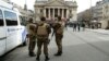 Belgian soldiers stand guard next to one of the memorials to the victims of the recent Brussels attacks, at the Place de la Bourse in Brussels, March, 27, 2016. 