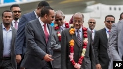 Eritrea’s foreign minister, Osman Saleh Mohammed, center right, is welcomed by Ethiopia’s prime minister, Abiy Ahmed, center left, upon the Eritrean delegation’s arrival at the airport in Addis Ababa, Ethiopia, June 26, 2018. 