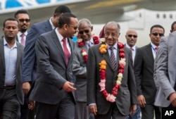FILE - Eritrea's Foreign Minister Osman Sale, center right, is welcomed by Ethiopia's Prime Minister Abiy Ahmed, center left, upon the Eritrean delegation's arrival at the airport in Addis Ababa, Ethiopia, June 26, 2018.
