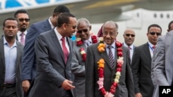 Eritrea's Foreign Minister Osman Sale, center right, is welcomed by Ethiopia's Prime Minister Abiy Ahmed, center left, upon the Eritrean delegation's arrival at the airport in Addis Ababa, Ethiopia, June 26, 2018.