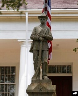 In this Wednesday, Aug. 1, 2018 photo, a statue commemorating fallen confederate soldiers stands on front of the East Feliciana Parish Courthouse in Clinton, La.