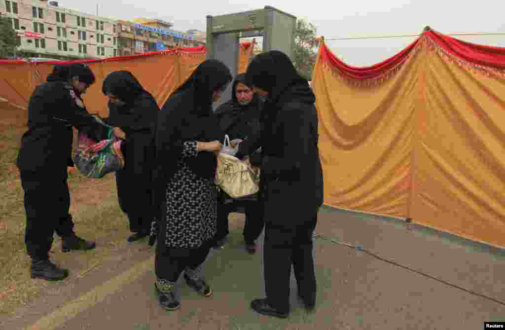 Policewomen check the bags of Shi&#39;ite Muslim women ahead of Ashura ceremony to mark the death of Hussein, the grandson of Prophet Mohammad, at Asna Ashri mosque in Islamabad November 23, 2012. Muslims all over the world mourn the slaying of Imam Hussein, grandson of Prophet Mohammad, during the first ten days of the Islamic month of Muharram. Imam Hussein was killed by his political rivals along with 72 companions in the seventh century battle of Kerbala. REUTERS/Faisal Mahmood (PAKISTAN - Tags: POLITICS CIVIL UNREST RELIGION SOCIETY)