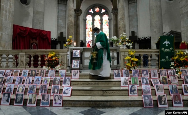 Barisan foto dari perempuan yang meninggal akibat menjadi korban kekerasan terpampang di altar Gereja Katedral di La Paz, Bolivia, pada 25 November 2021, sebagai bagian dari peringatan Hari Anti Kekerasan Terhadap Perempuan. (Foto: AP/Juan Karita)