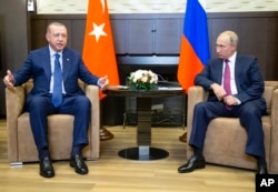 FILE - Turkish President Recep Tayyip Erdogan (L) speaks to Russian President Vladimir Putin, during their meeting in the Bocharov Ruchei residence in the Black Sea resort of Sochi in Sochi, Russia, Sept. 17, 2018.