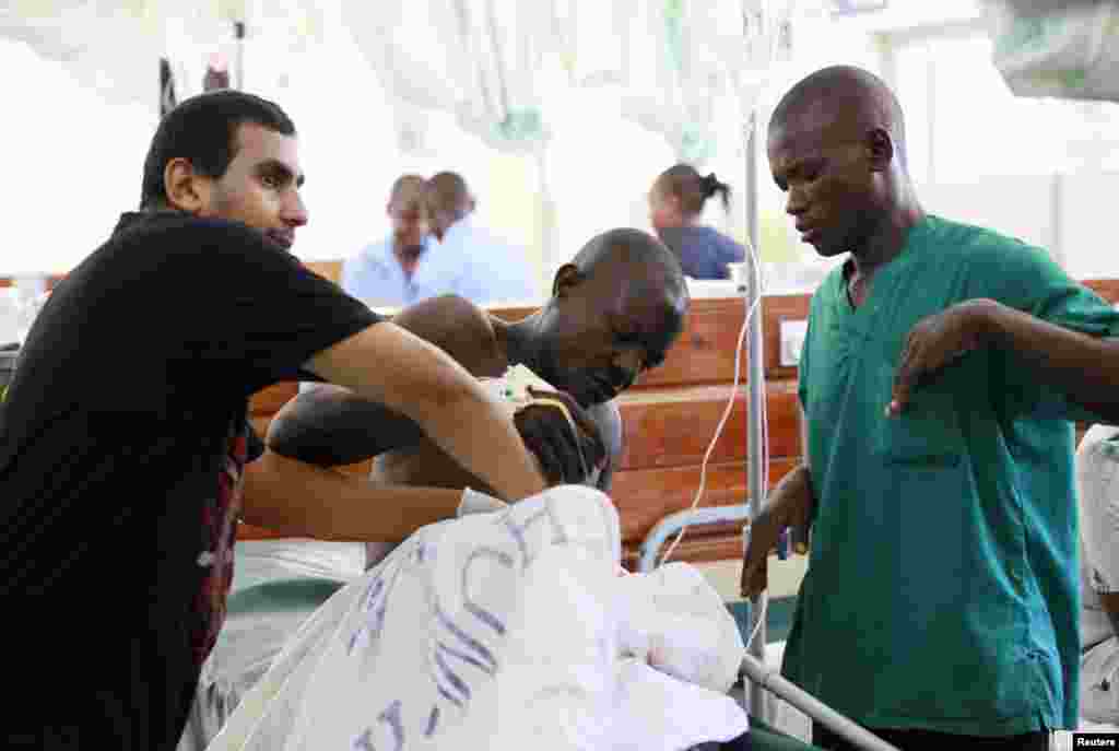 A medic attends to an injured man, a victim from an attack on a church by gunmen, at the Coast General Hospital, Mombasa, Kenya, March 23, 2014. 