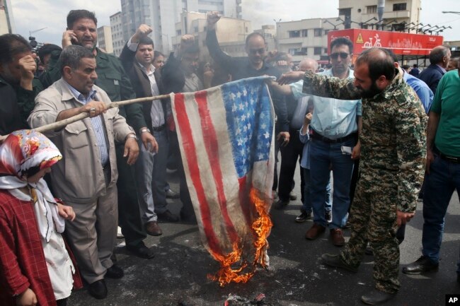 ABŞ-ın İnqilabi Qvardiyanı terrorçu təşkilat elan etməsindən sonra etirazçılar ABŞ bayrağının maketini yandırır. Tehran, İran, 12 aprel, 2019.