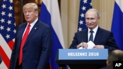 FILE - U.S. President Donald Trump, left, and Russian President Vladimir Putin arrive for a press conference after their meeting at the Presidential Palace in Helsinki, Finland, July 16, 2018.