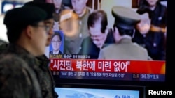 12月13日首尔火车站：韩国士兵走过电视上金正恩处决张成泽的报道镜头