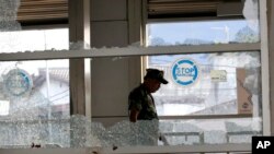 Seorang perwira militer memeriksa sebuah halte bus yang rusak akibat ledakan bom bunuh diri di Kampung Melayu, Jakarta, Indonesia, Rabu, 25 Mei 2017. Presiden Indonesia Joko "Jokowi" Widodo memerintahkan penyelidikan menyeluruh terhadap jaringan di balik dua pemboman bunuh diri yang menarget polisi.