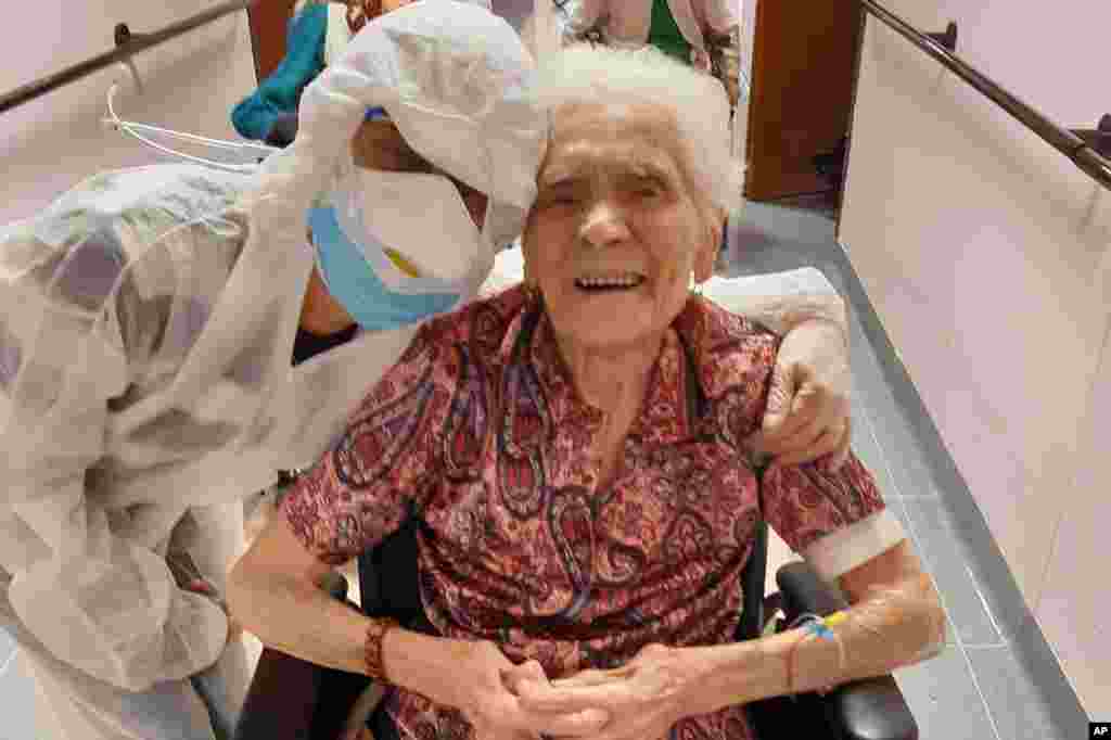 En esta foto tomada el 1 de abril de 2020, Ada Zanusso, de 103 años, posa con una enfermera en la casa de ancianos &quot;Maria Grazia&quot; en Lessona, en el norte de Italia, después de recuperarse tras el contagio con la COVID-19. Para recuperarse de la infección por coronavirus, Zanusso recomienda coraje y fe, las mismas cualidades que le han servido en más de un siglo de vida. El coronavirus ha demostrado ser especialmente letal en los adultos mayores y las personas con problemas de salud existentes.