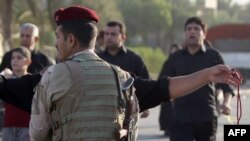 An Iraqi soldier mans a checkpoint on a road in Baghdad’s northern district of Kadhimiya on October 6, 2013 as Shiite pilgrims walk to a shrine to commemorate the death of Imam Mohammed al-Jawad, the ninth Shiite Imam. 