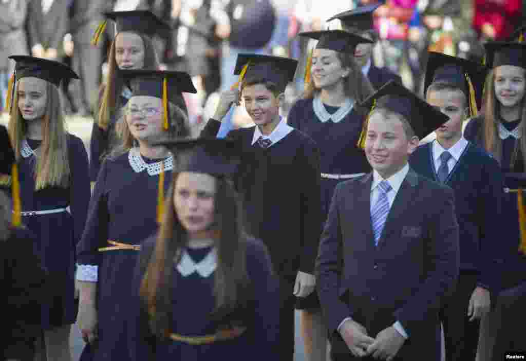 Pupils attend a festive ceremony to mark the beginning of another academic year in Makiivka, eastern Ukraine, Oct. 1, 2014. 