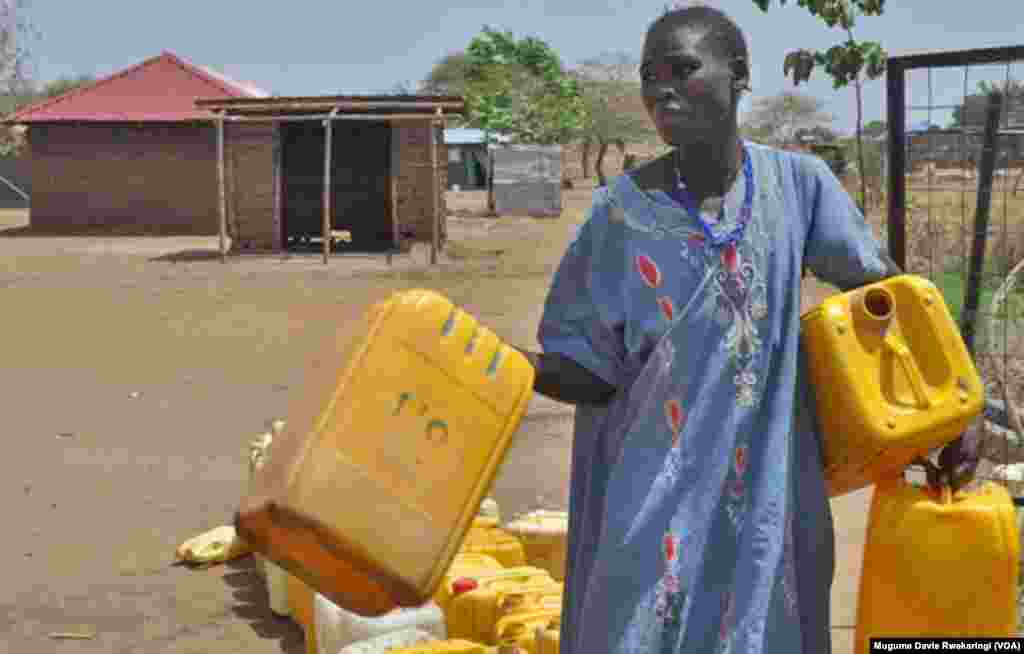 A South Sudanese woman carries plastic jerrycans to collect water in Gudere, near Juba in South Sudan. The country's under-developed infrastructure means that water resources are still strained in most areas. (VOA/Mugume Davis Rwakaringi)