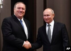 Russian President Vladimir Putin, right, and U.S. Secretary of State Mike Pompeo, pose for a photo before their talks in the Black Sea resort city of Sochi, southern Russia, May 14, 2019.