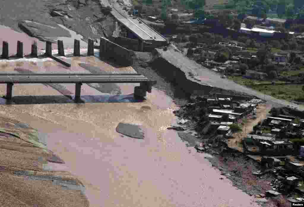 An aerial view taken from an Indian Air Force helicopter shows the remains of a bridge after it was swept away by floodwaters from the river Tawi on the outskirts of Jammu, Sept. 9, 2014.