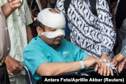 FILE - Novel Baswedan, an investigator at the country's Corruption Eradication Commission (KPK), sits in a wheelchair on his way to an eye hospital for special treatment after an unidentified attacker threw acid at him, in Jakarta, Indonesia, April 11, 2017.