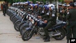 Cambodian military police officers stand by with their motorcycles at Stung Meanchey where Prime Minister Hun Sen made his first public appearance since Sunday's election, in Phnom Penh, July 31, 2013.