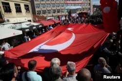 FILE - People carry the Turkish flag as Turkish President Recep Tayyip Erdogan and his Serbian counterpart, Aleksandar Vucic, visit Novi Pazar, Serbia, Oct. 11, 2017.